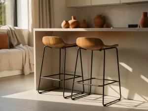 Twee elegante barkrukken met eiken zitting en mat zwart metalen frame aan een keukeneiland in zacht ochtendlicht.