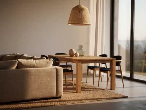 Linnen bank en eiken eettafel in open woonruimte met geweven hanglamp, warme zandtinten en zacht middaglicht.